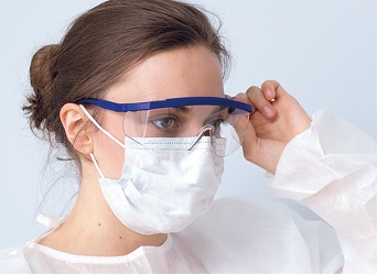 Woman wearing protective googles, a respirator mask and a protective gown