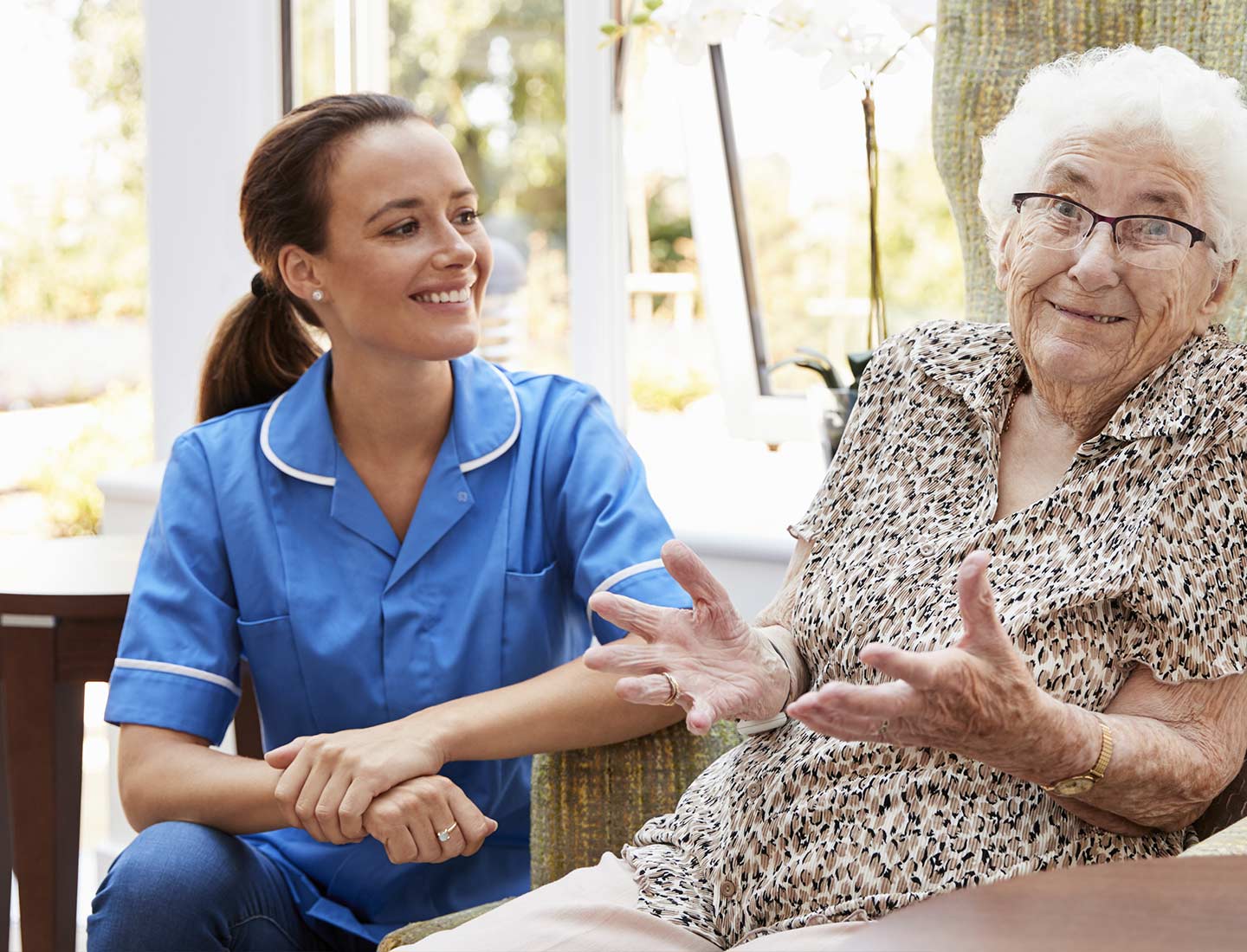 Pflegekraft mit Seniorin in Gespräch