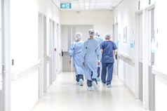Medical staff walking away in a bright hospital hallway